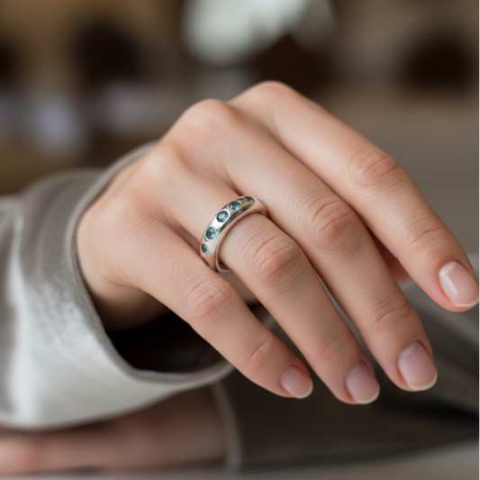 Hand wearing a ring with aquamarines with a blurred background