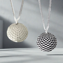 Two Silver domed pendants one with oxidized design the other high polished hanging on a grey background