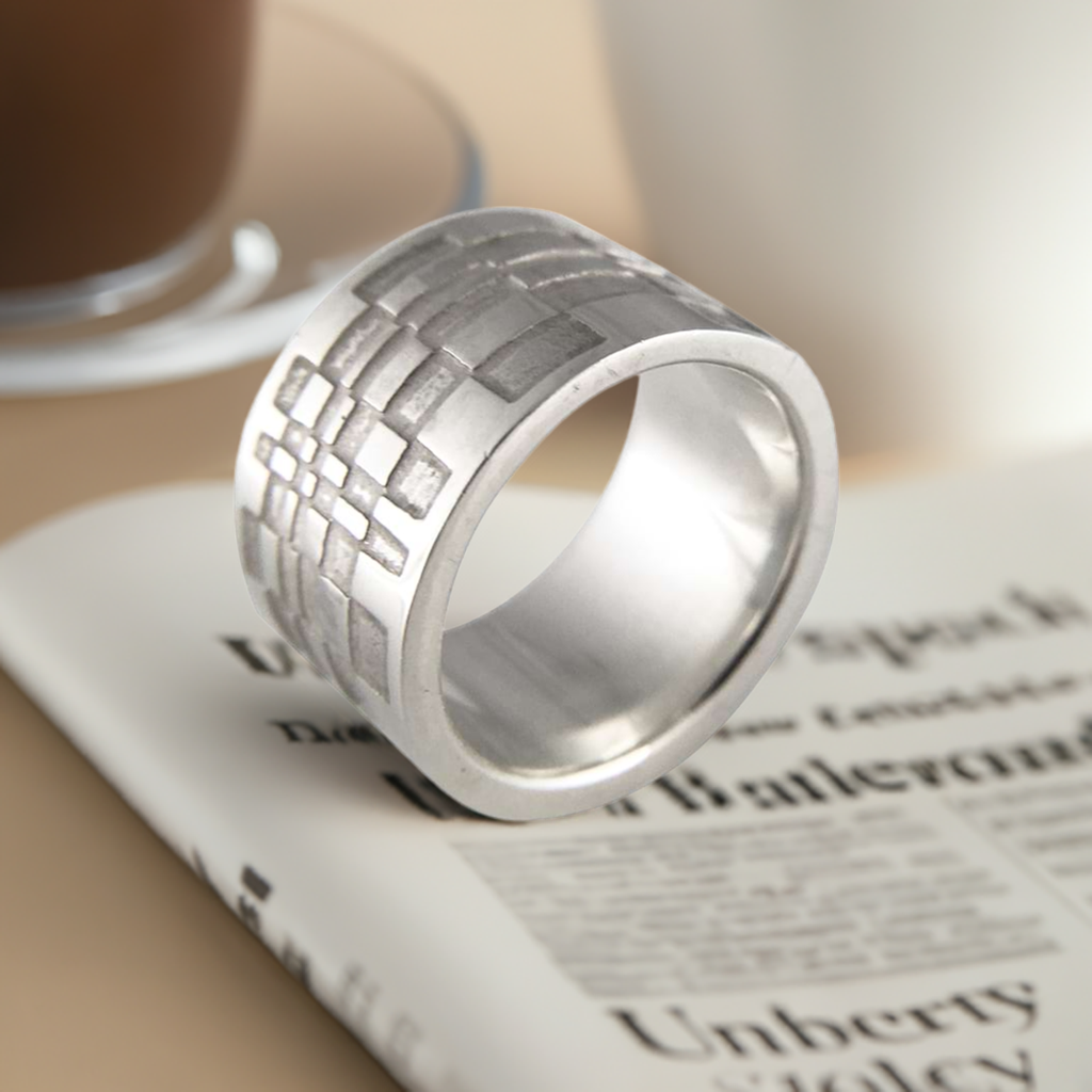 Silver thumb ring positioned on top of a newspaper