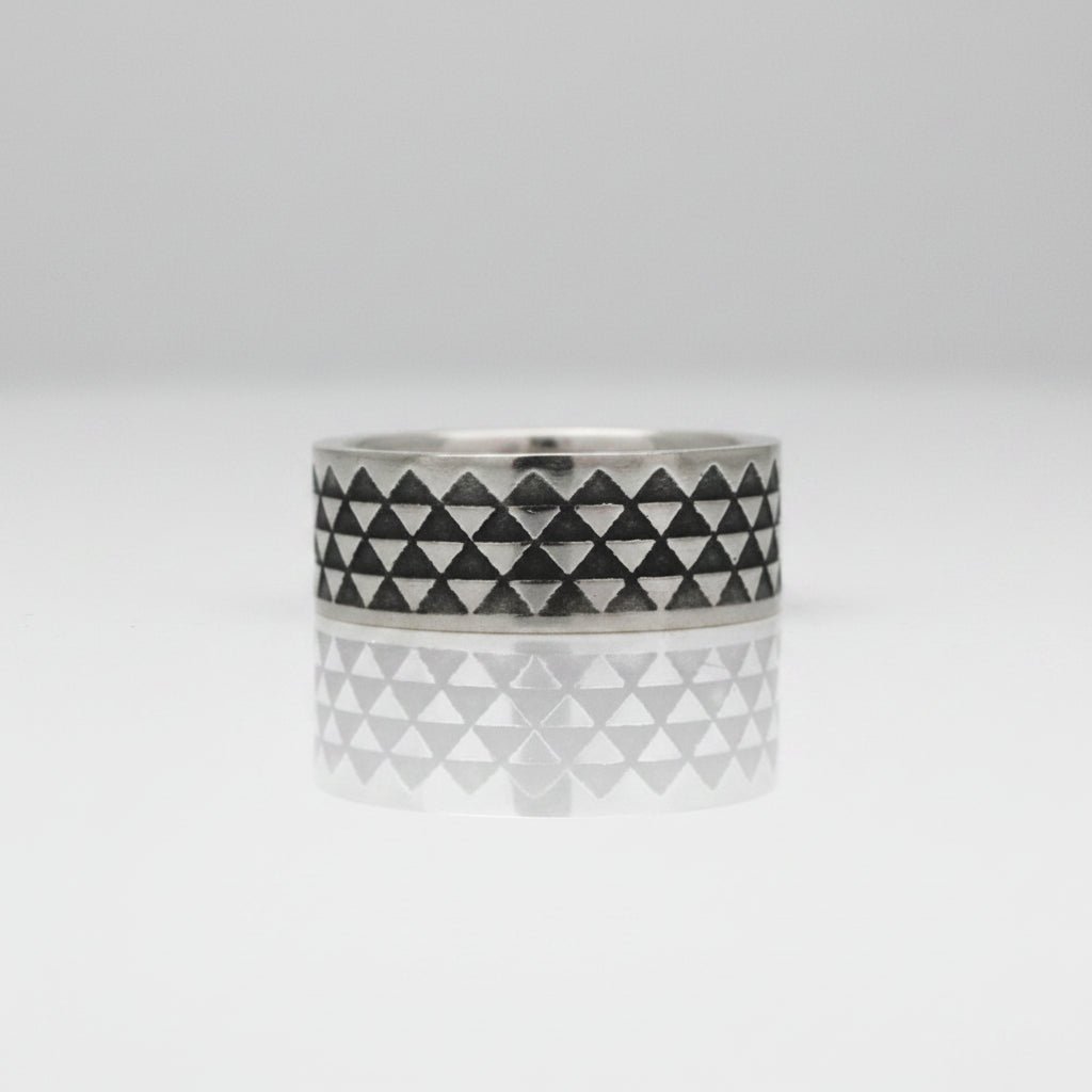 triangle ring with oxidised design detail on a white background