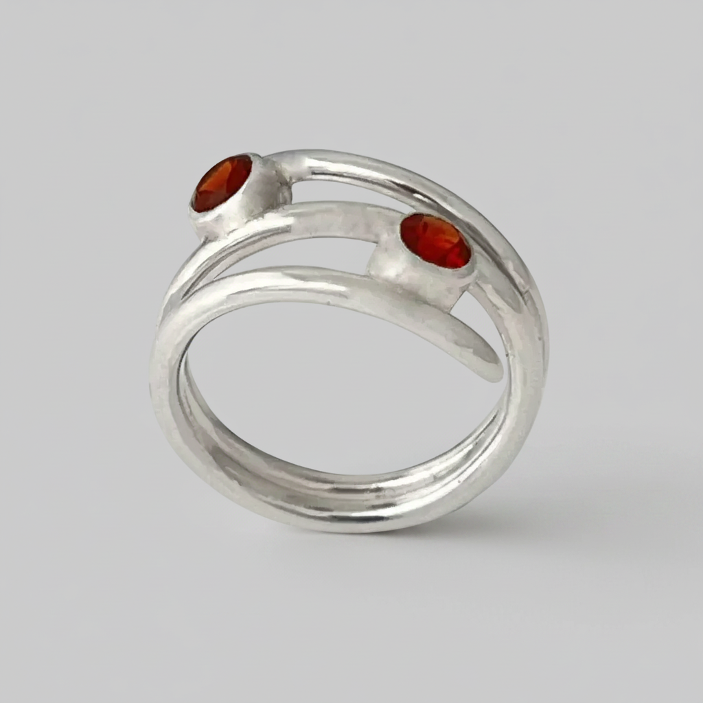 Silver ring with red stones on a light gray background