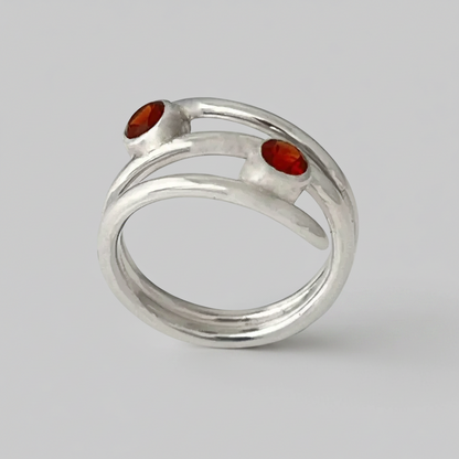 Silver ring with red stones on a light gray background