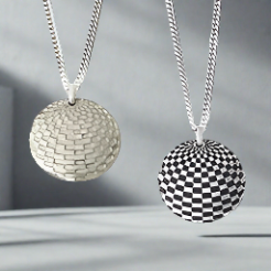 Two Silver domed pendants one with oxidized design the other high polished hanging on a grey background 