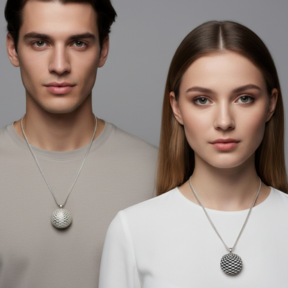 Man and woman wearing silver necklaces with circular pendants against a gray background