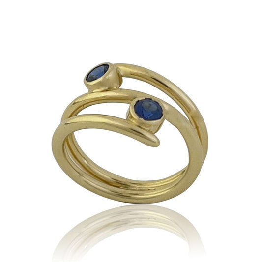 18kt yellow gold ring with 2 blue sapphires gemstones with a coiled shape