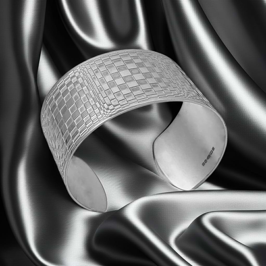 silver wide cuff with abstract pattefn on a silver fabric backdrop