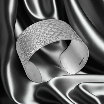 silver wide cuff with abstract pattefn on a silver fabric backdrop