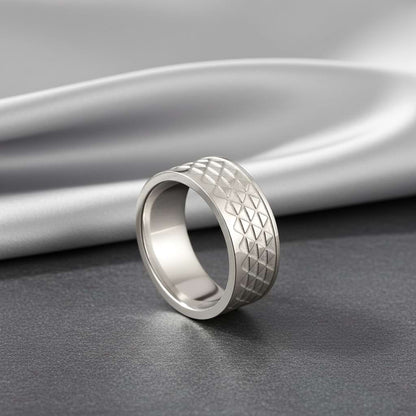Silver unisex ring with triangle pattern with a silver fabric bakdrop