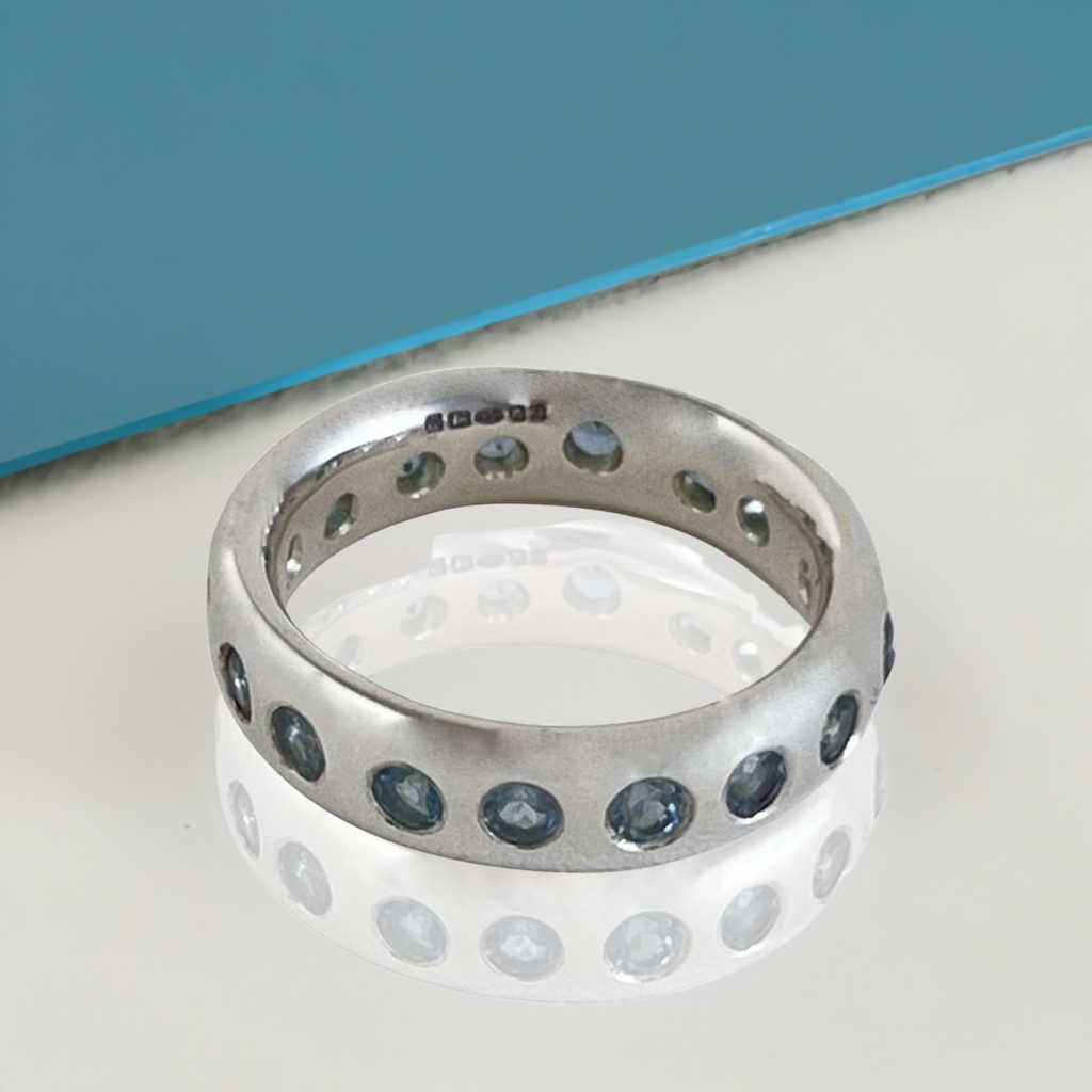 eternity ring with aqua gemstones floating in a white and blue base