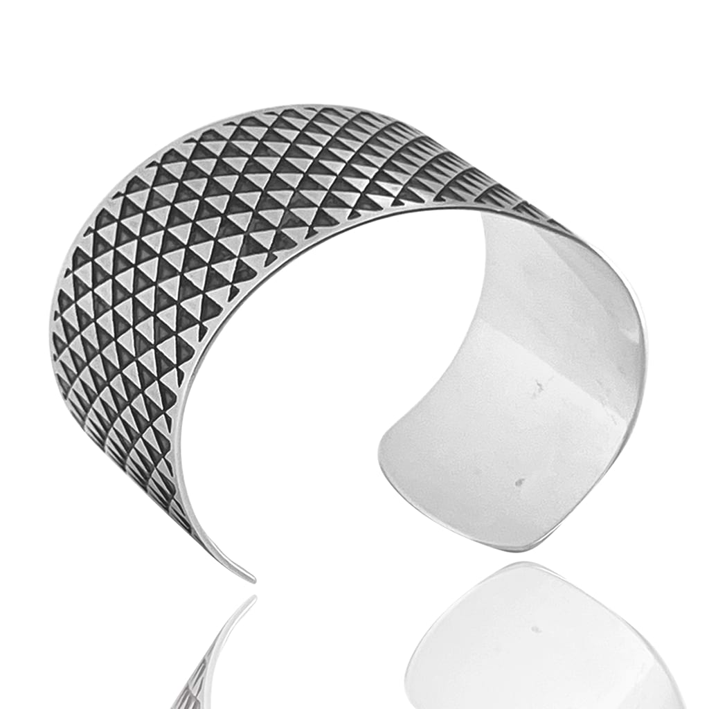 silver cuff bracelet with triangle pattern on a white background