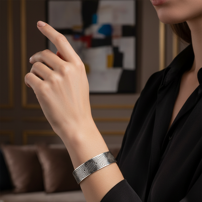 Person wearing a silver bracelet in an indoor setting