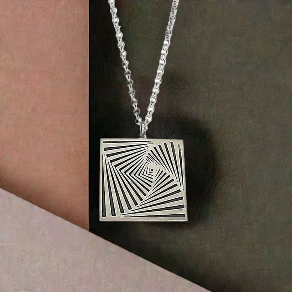 Silver square pendant in front of pastel coloured background