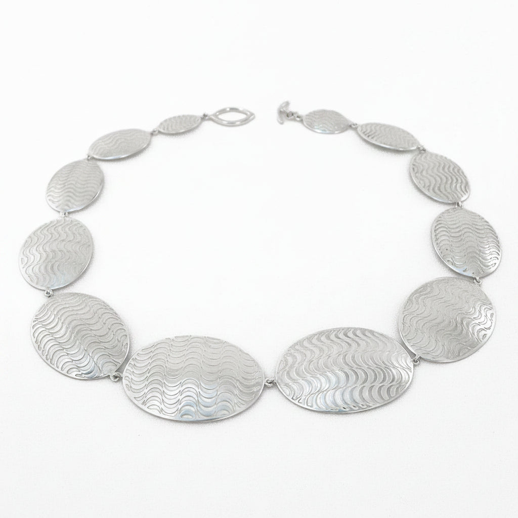 Silver necklace with oval pendants on a white background