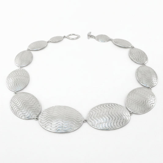 Silver necklace with oval pendants on a white background