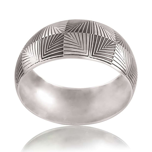 BANGLE BRACELET WITH SPHERICAL SHAPE FEATURING A PARTIALLY OXIDISED OPTICAL DESIGN PHOTOGRAPHED ON A WHITE BACKGROUND