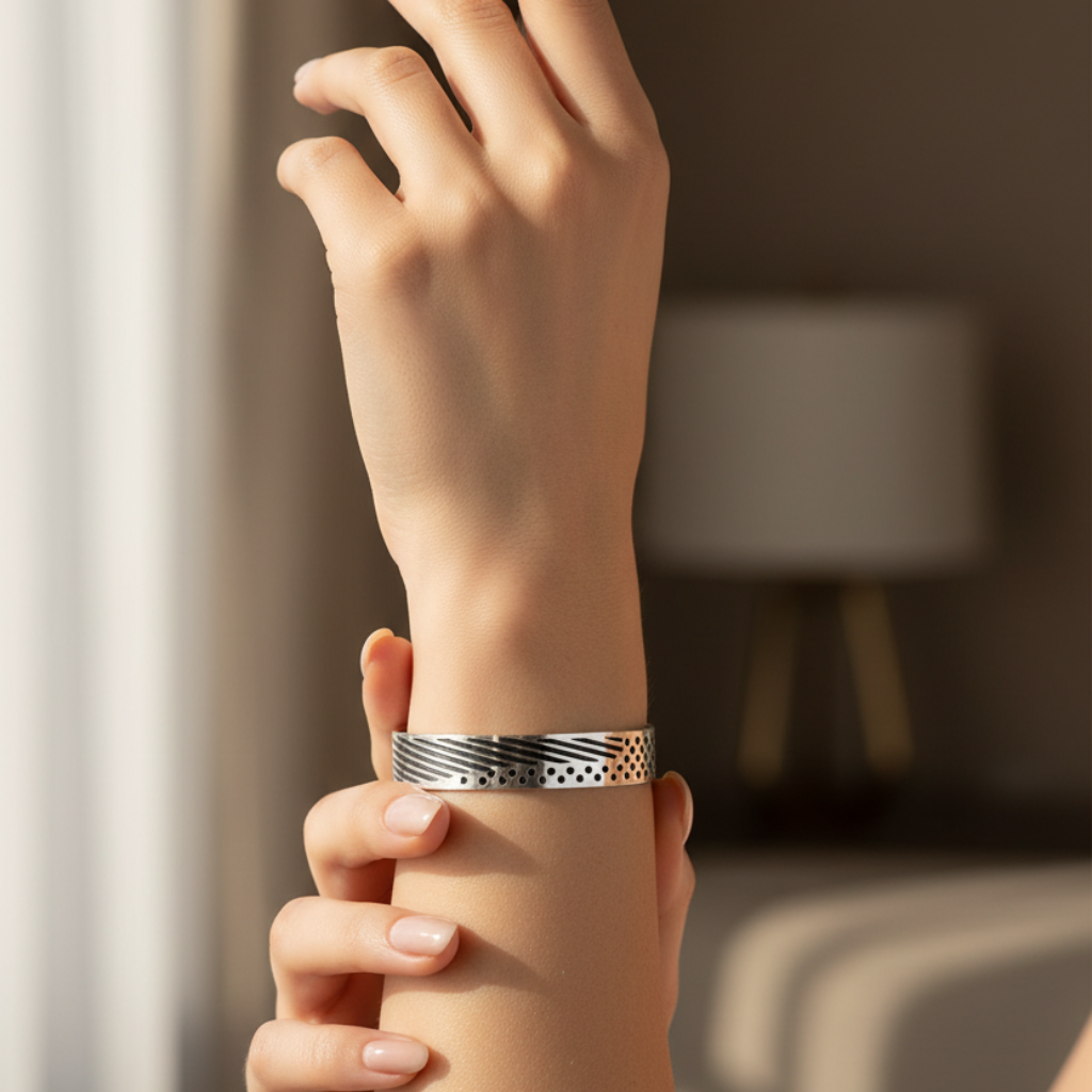 Hand wearing a silver bracelet with a blurred background