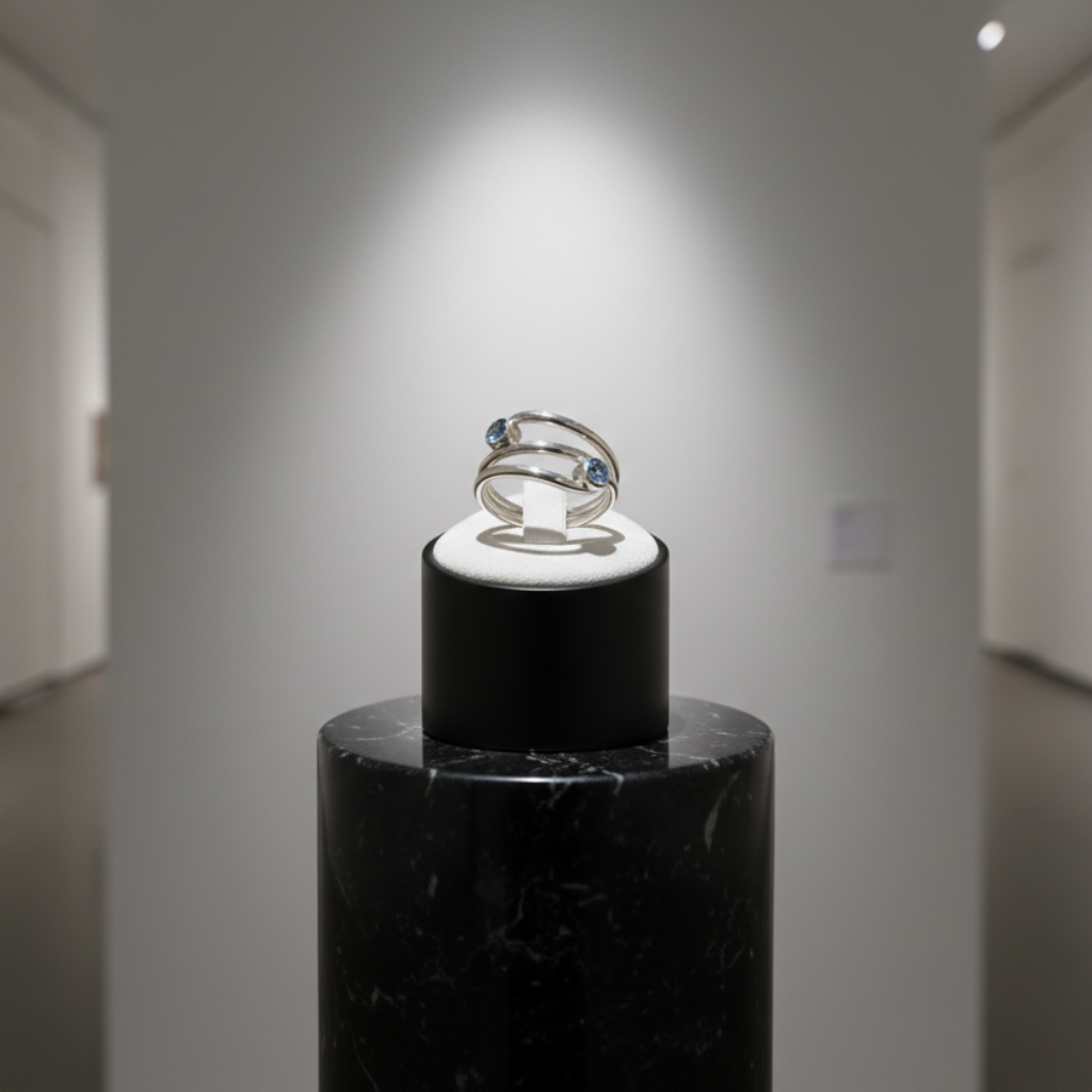 Ring on a black stand in a gallery setting