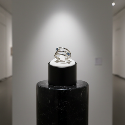 Ring on a black stand in a gallery setting