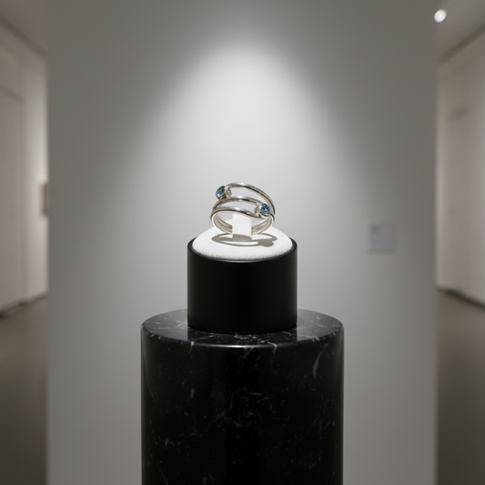 Ring on a black stand in a gallery setting