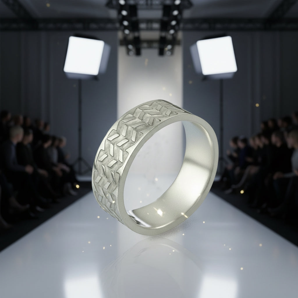 Silver ring with geometric pattern on a runway with audience