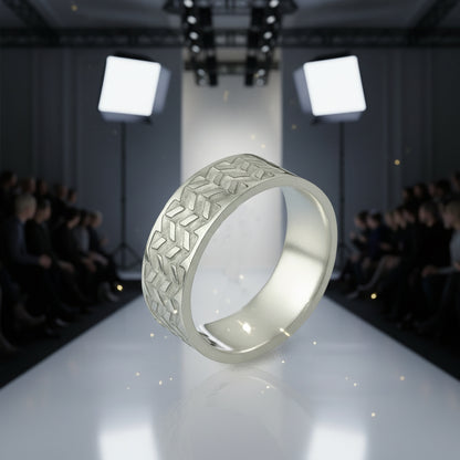 Silver ring with geometric pattern on a runway with audience