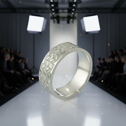 Silver ring with geometric pattern on a runway with audience