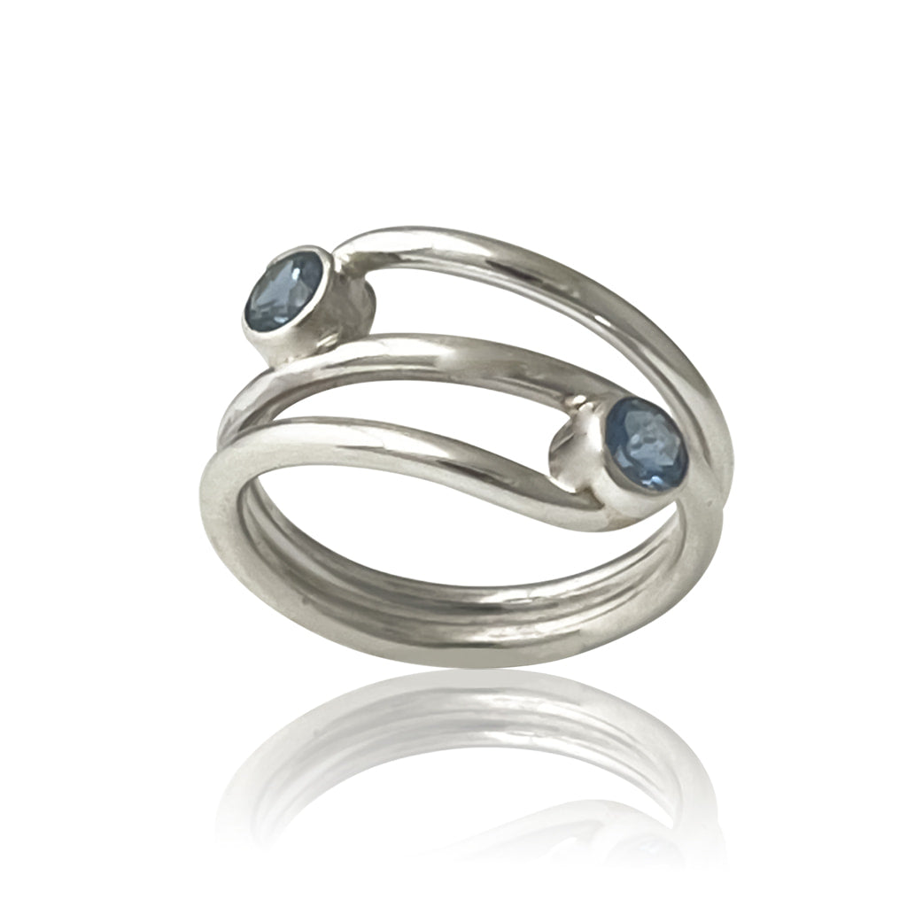silver ring with two aquamarine gemstones on a white background