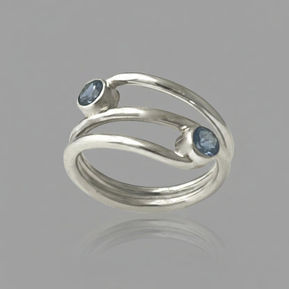 Silver ring with two aquamarine gemstones on a white background