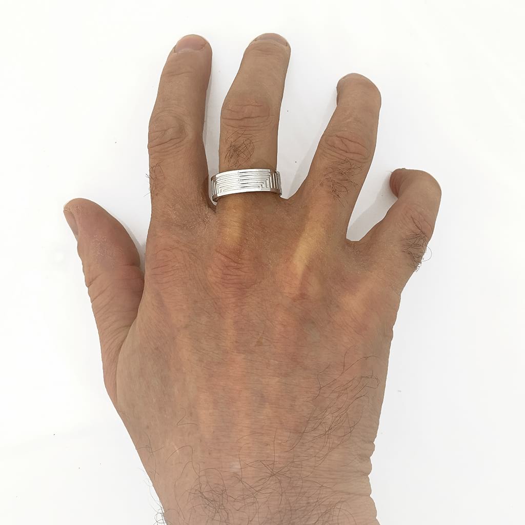Silver Ring Band with Geometric Lines Worn on a White Background