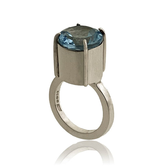 Silver ring with faceted Topaz gemstone on a white abckground