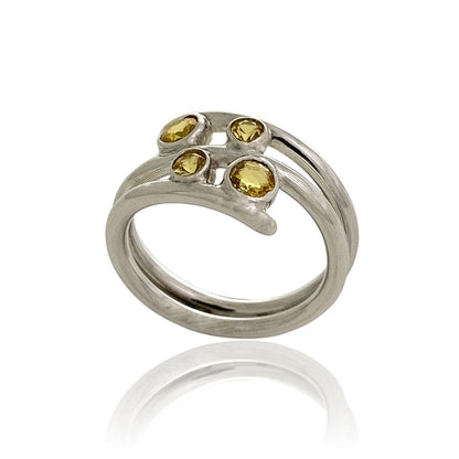 A women silver ring with yellow sapphires sideview on a white background